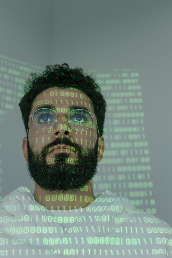 Services A bearded man with eyeglasses analyzing data in a digital environment with green binary code projections.